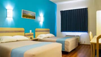 A hotel room with two beds, a desk, a chair, a window with curtains, and a painting on the wall.