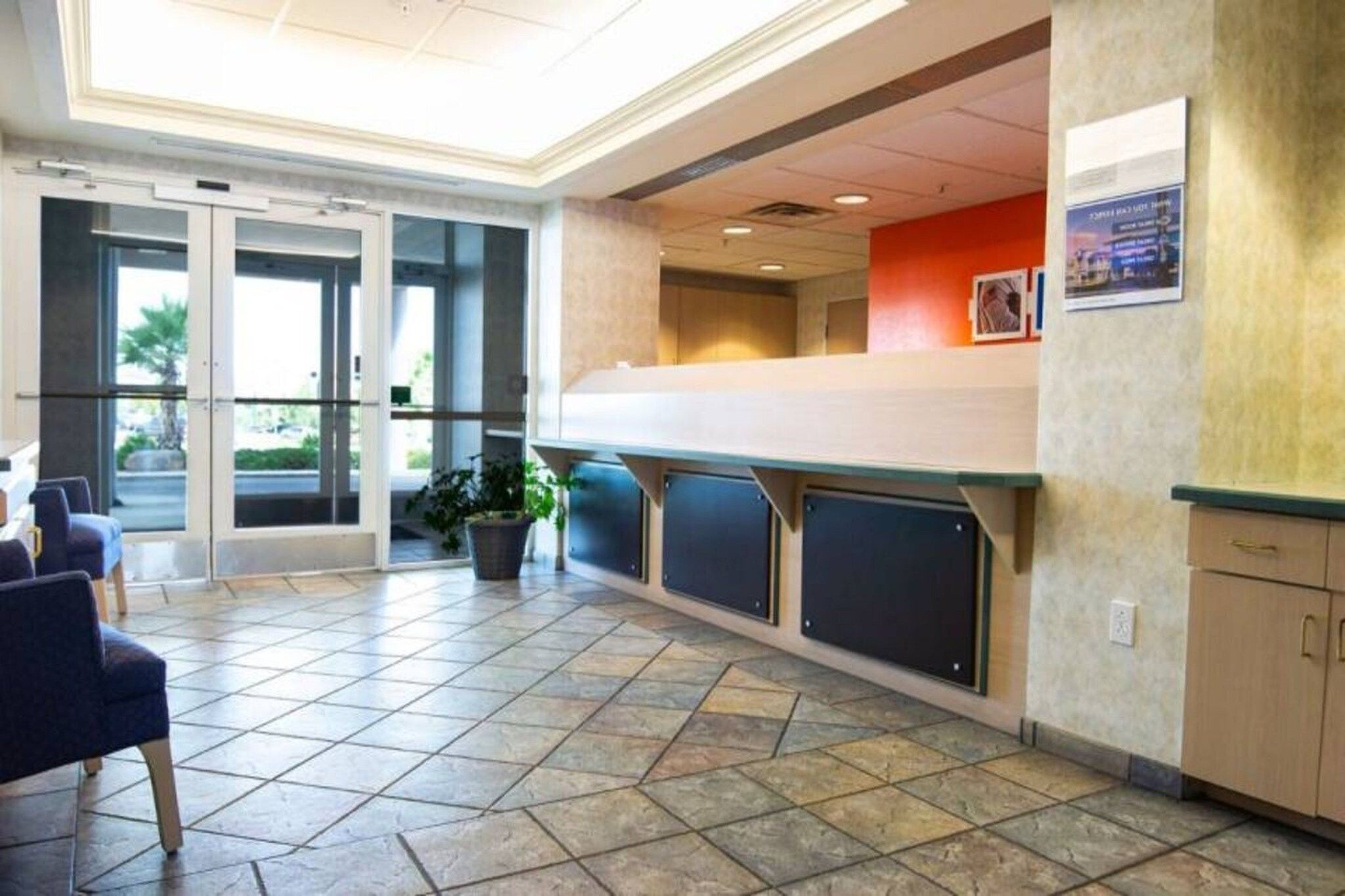 A reception area with a counter, seating, and a potted plant.