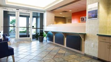 A reception area with a counter, seating, and a potted plant.
