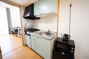 A compact kitchen with a stove, sink, and a coffee maker. - goom Monthly Nakasu JOJO (Fukuoka City Chuo ku Haruyoshi)