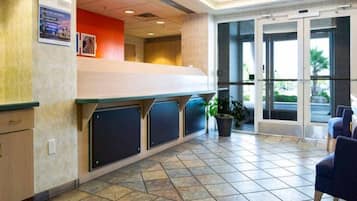 A reception area with a counter, seating, and a view of the outdoors.