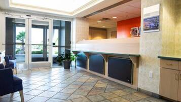 A reception area with a counter, seating, and a potted plant.