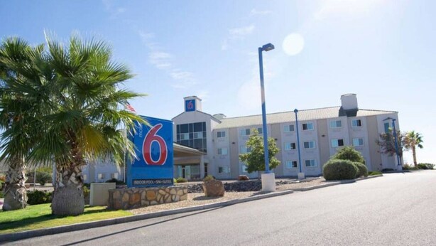 Hotel com grande placa indicando 6 quartos, piscina interna e suítes de spa.