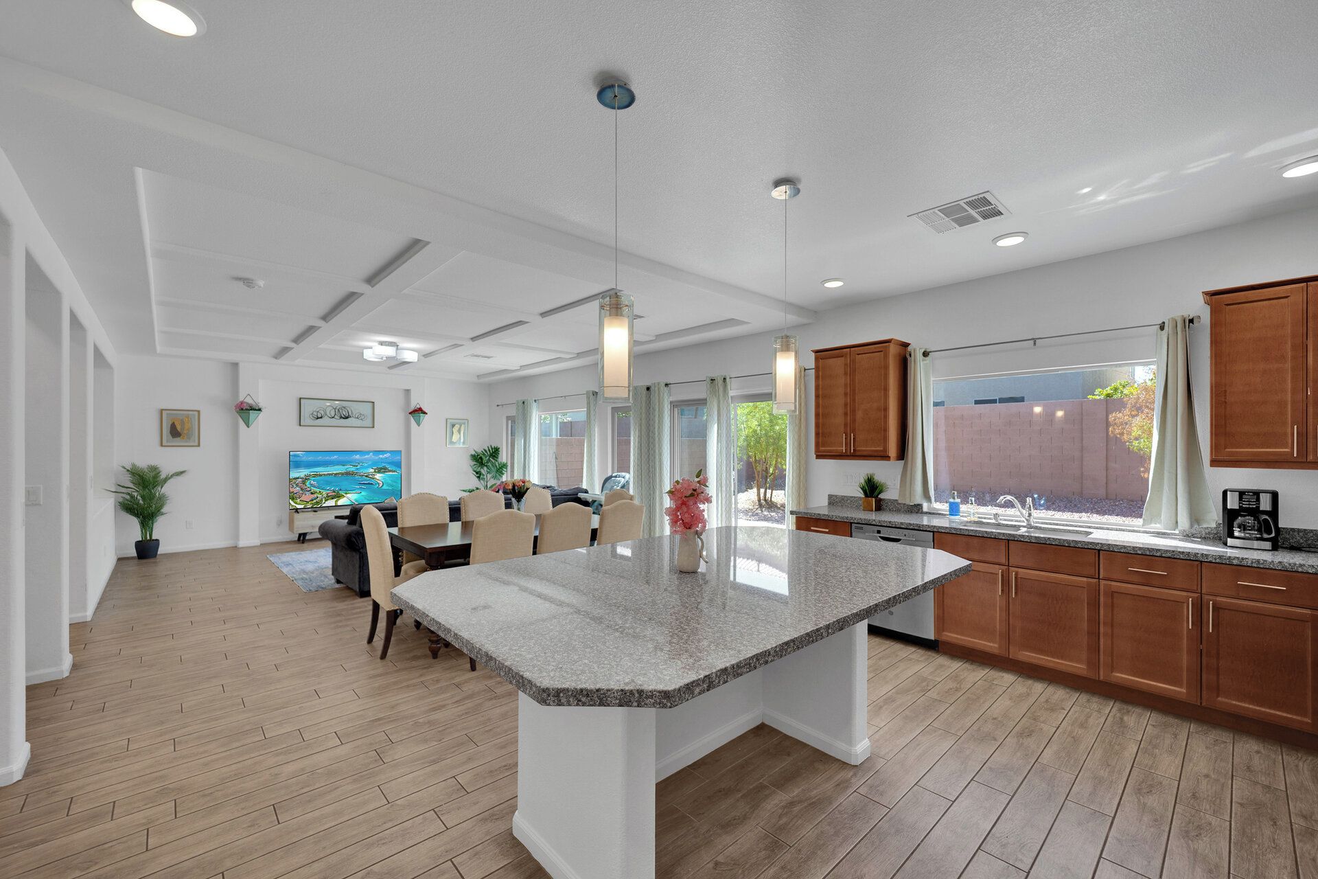 A modern kitchen with granite countertops, wooden cabinets, and a dining area with a large island.