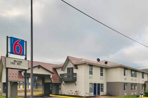 Un motel avec une grande enseigne indiquant qu’il s’agit du numéro 6, et une pancarte d’accueil faisant la publicité d’un accès Wi-Fi gratuit.