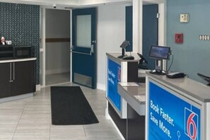 Een receptiegedeelte met een bureau, computer en een bord waarop een snellere service wordt aangeboden.