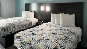 A hotel room with two beds, each with patterned bedding, a dark headboard, and wall-mounted lights. - Cozy Full Bed Room|Free Parking (East Syracuse)