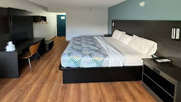 Een hotelkamer met een bed, een bureau, een stoel en een televisie.