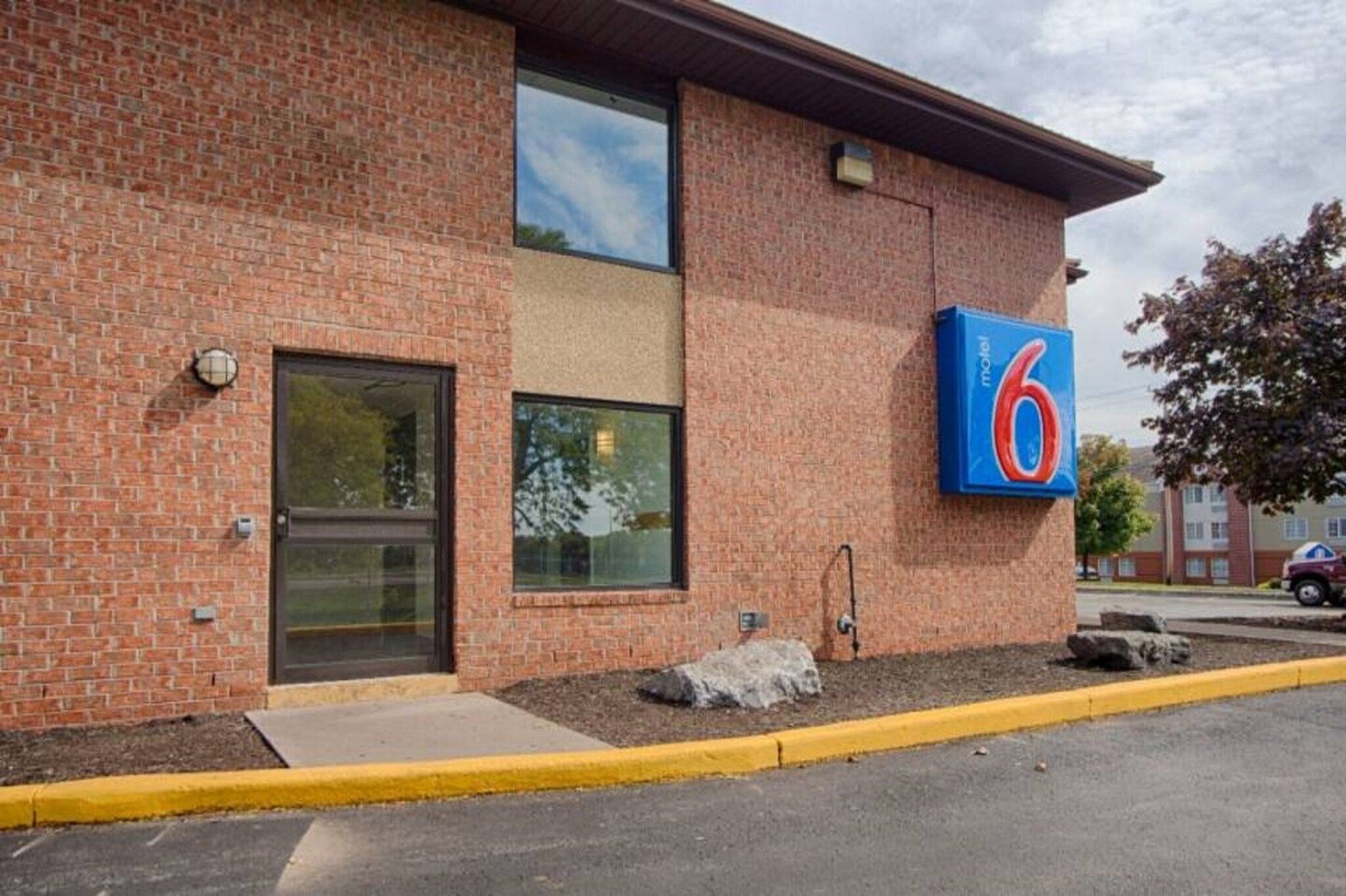 A brick building with a large number '6' sign, a door, and a window.
