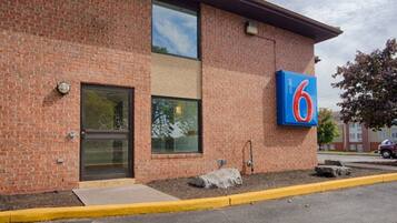 A brick building with a large number '6' sign, a door, and a window.