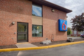A brick building with a large number '6' sign, a door, and a window.