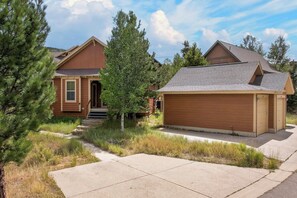 A two-story house with a front porch, a garage, and a well-maintained lawn.