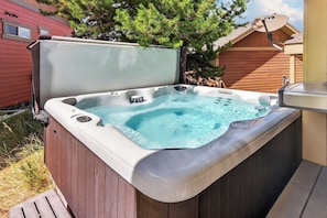 A hot tub with a lid, surrounded by a wooden deck, and a satellite dish on the roof.