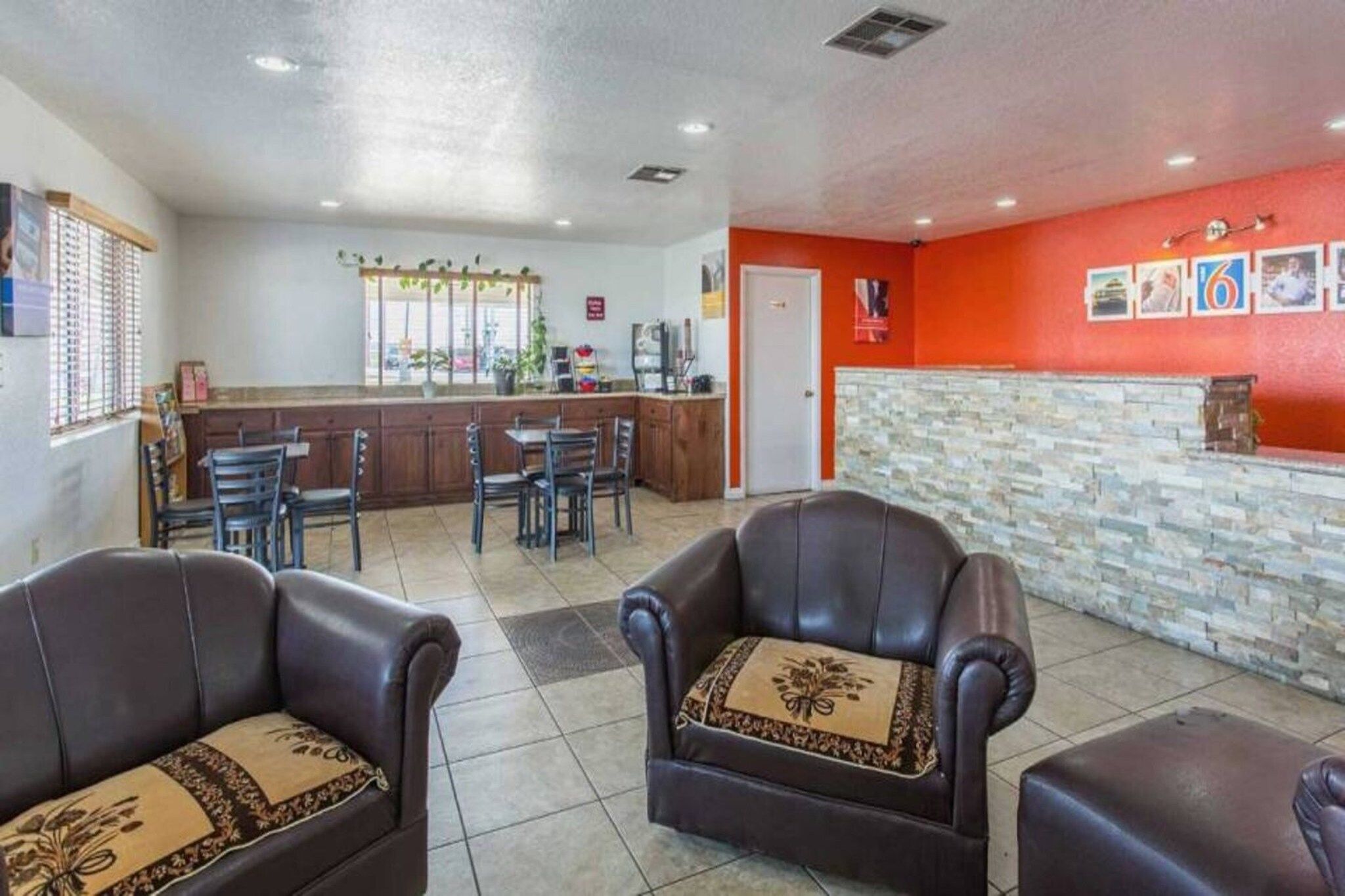 A lobby with leather armchairs, a reception desk, and a tiled floor.