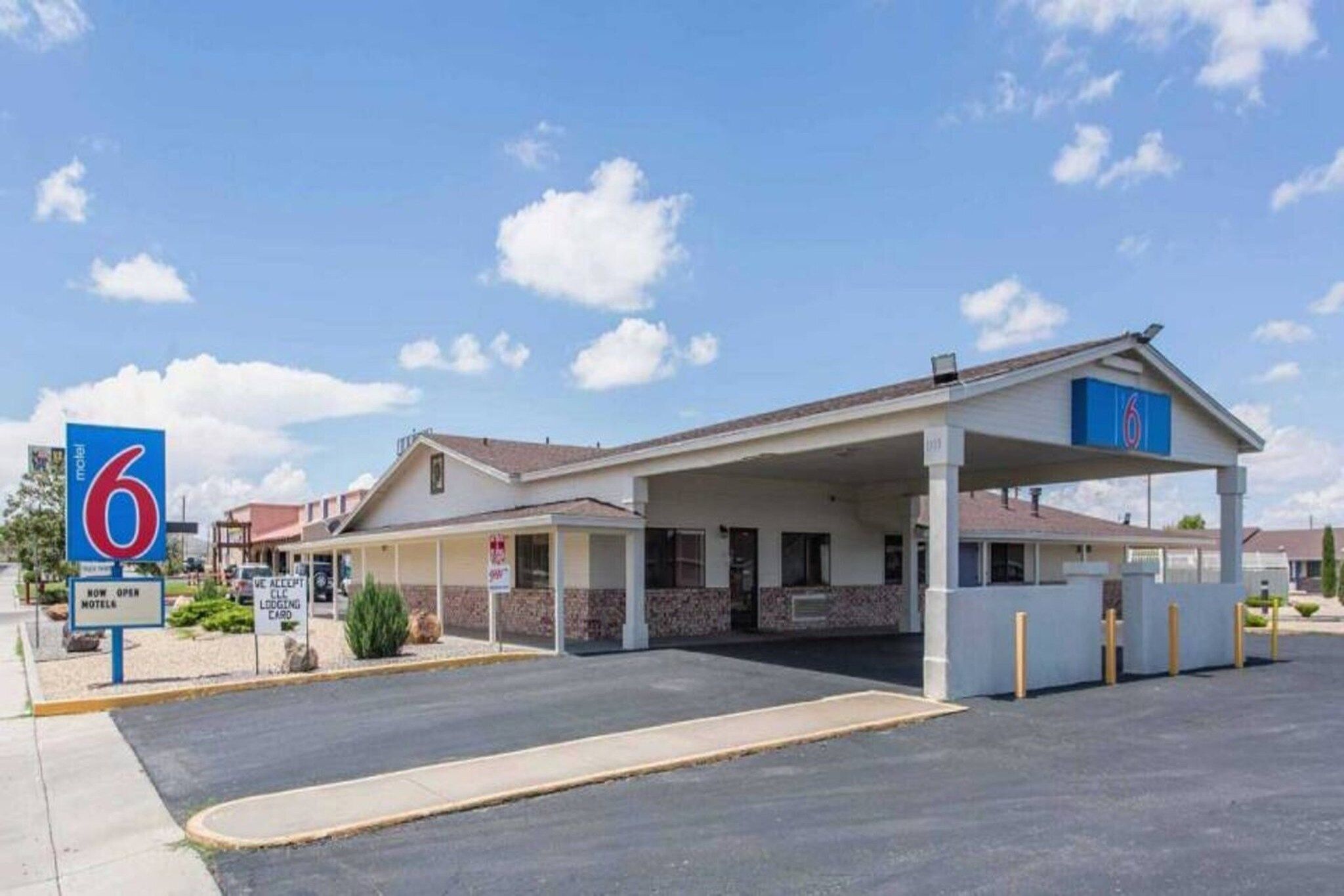 Motel 6 con estacionamiento techado y un edificio de una sola planta.