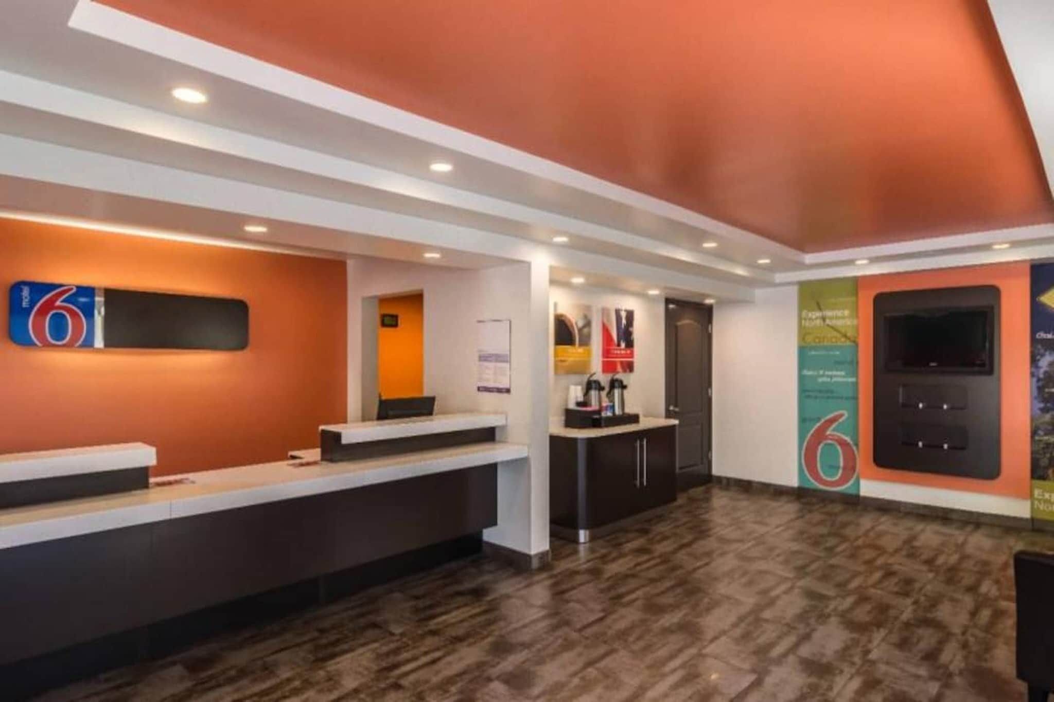 A reception area with a counter, a coffee machine, and a door in the background.