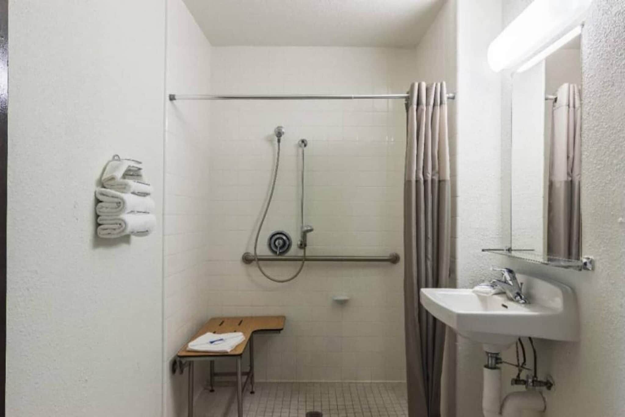 Un baño pequeño y funcional con ducha, lavabo e inodoro.