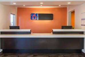 A reception desk with a digital display and two computer stations.