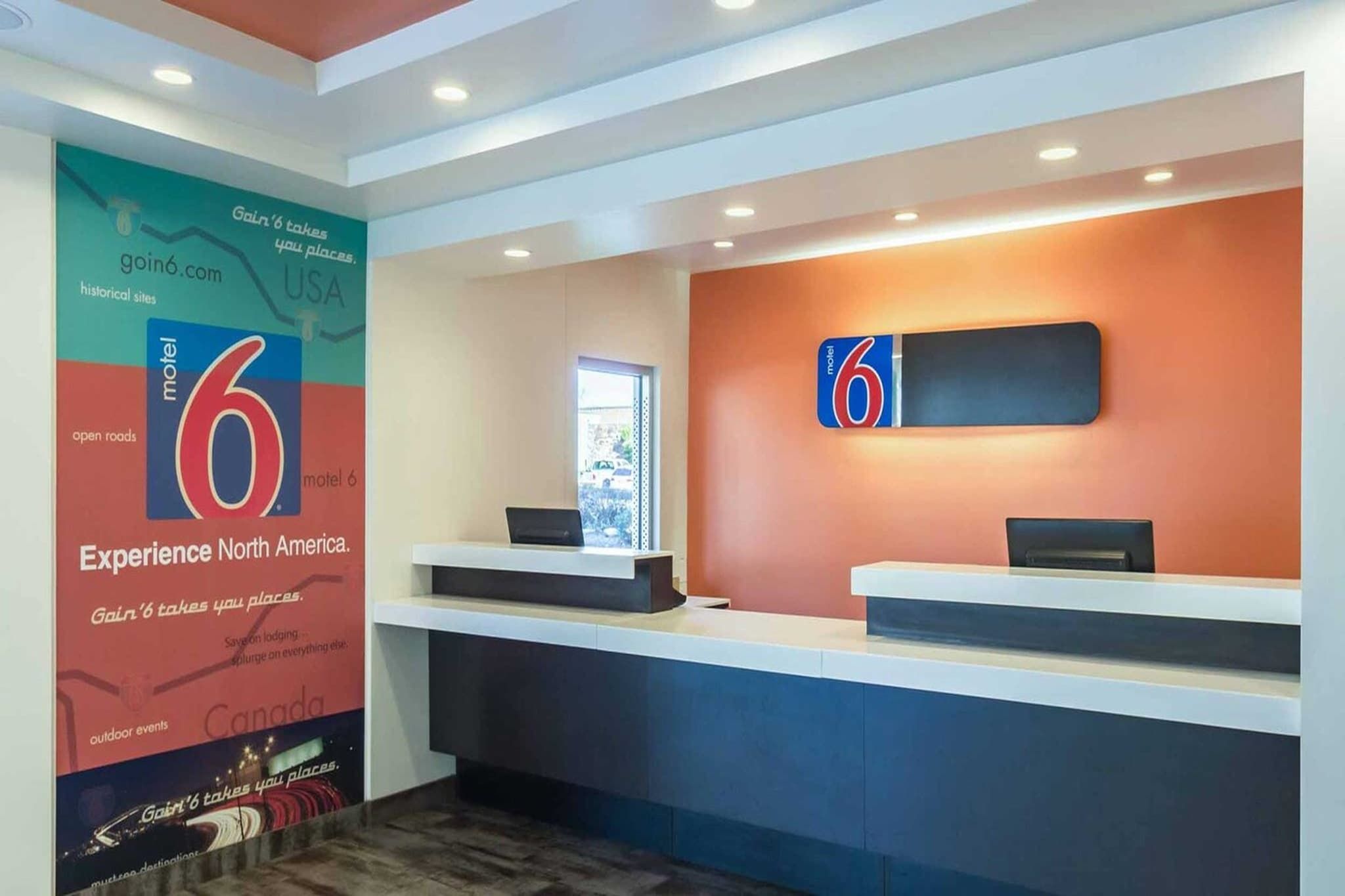 A reception area with a large '6' sign, a window, and a wall-mounted signboard.