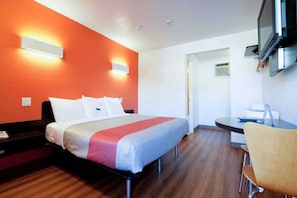 Ein Hotelzimmer mit einem Bett, einem Schreibtisch und einem Stuhl.