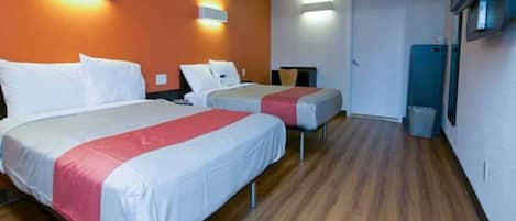 Ein Hotelzimmer mit zwei Betten, Holzboden und einer Tür zu einem Badezimmer.
