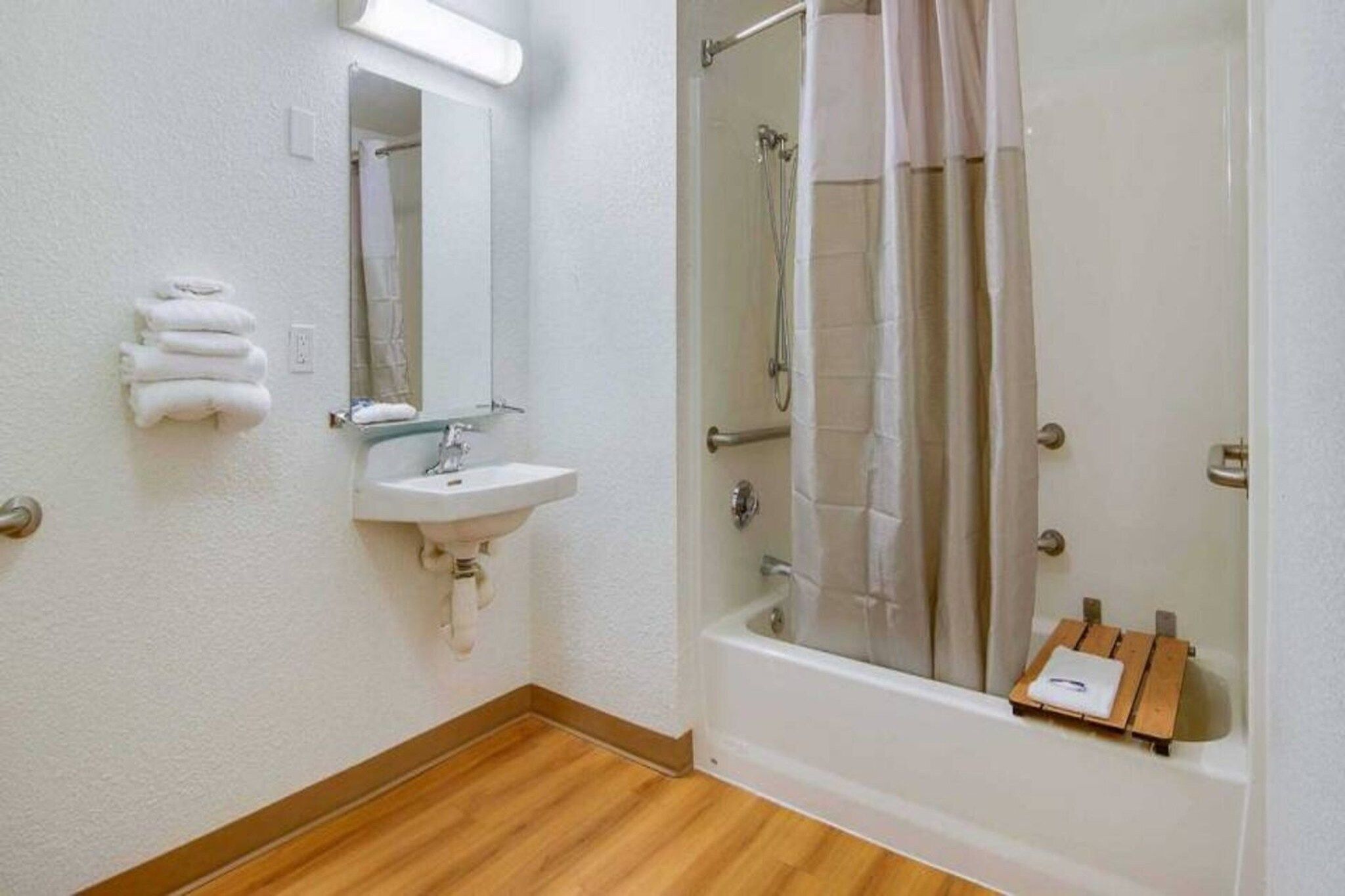 Une salle de bain avec un lavabo, un miroir et une douche.