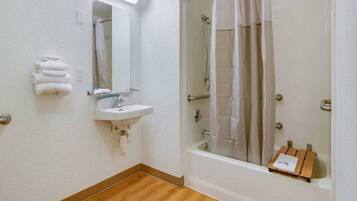Une salle de bain avec un lavabo, un miroir et une douche.