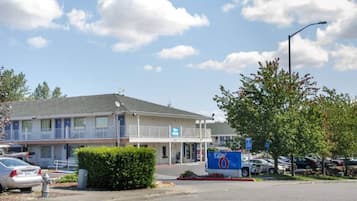 A motel with a parking lot, a sign indicating room number 6, and a street lamp.