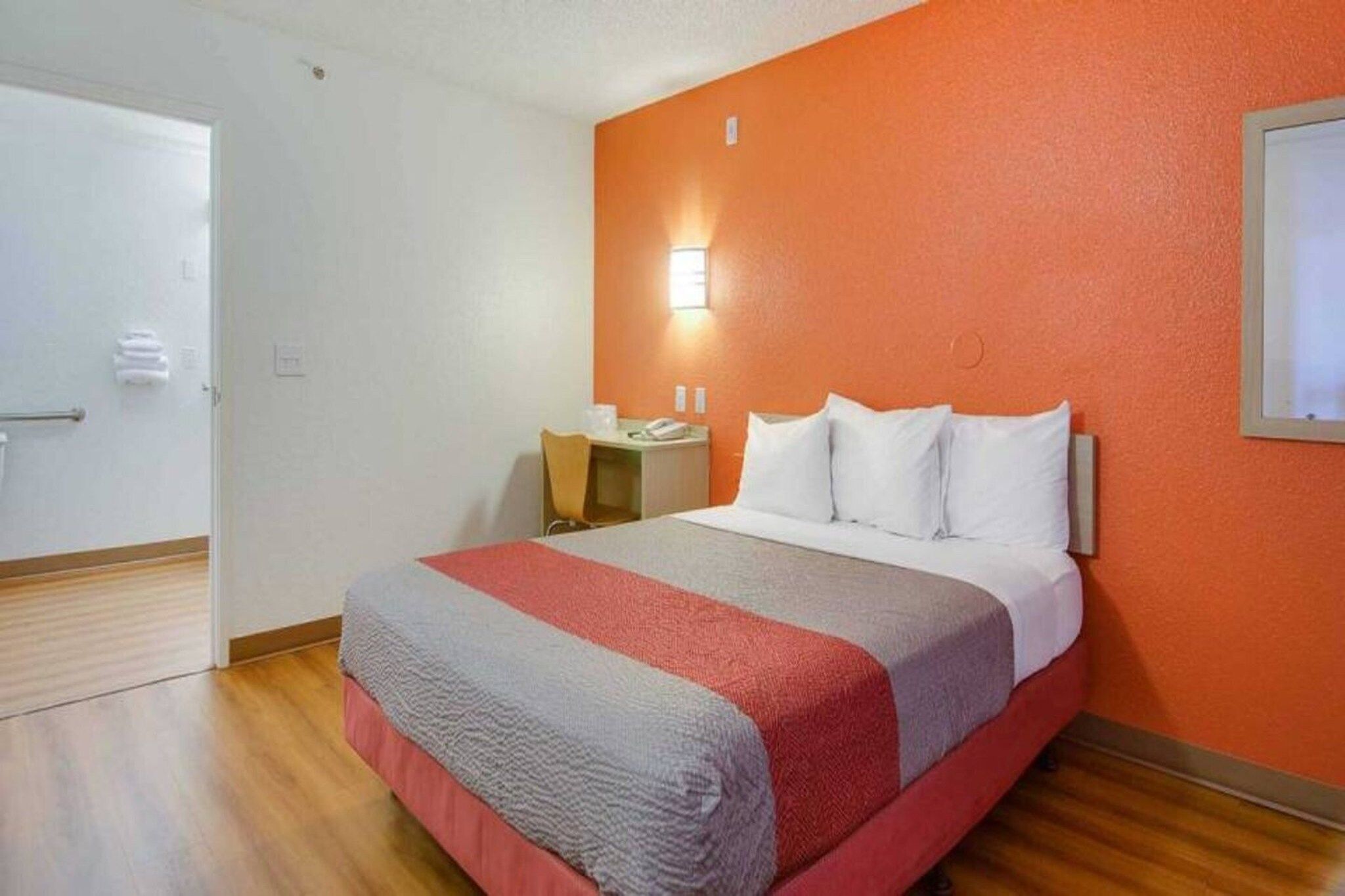 Une chambre d’hôtel avec un lit, un bureau et une chaise.