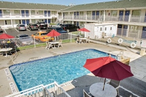 Ein Hotel mit Pool, Außenbereich und Parkplätzen.