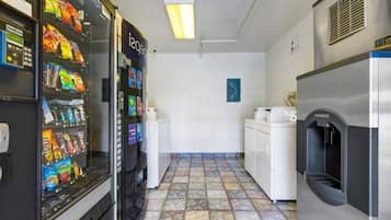 Une petite cuisine équipée d’un four à micro-ondes, d’un réfrigérateur et de distributeurs automatiques.