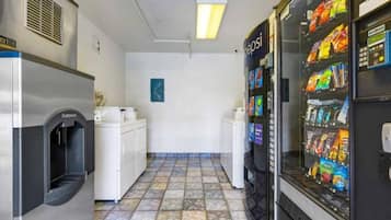 Un espace en libre-service comprenant un distributeur automatique, un réfrigérateur et un lave-linge.