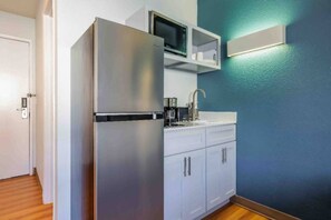 A compact kitchen with a refrigerator, microwave, and a coffee maker. - 1 Queen Bed | Mobil Access Tub Nsmk Micfridg (SeaTac)