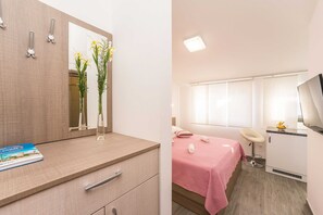 Ein Hotelzimmer mit Bett, Schreibtisch, Stuhl und Fenster.
