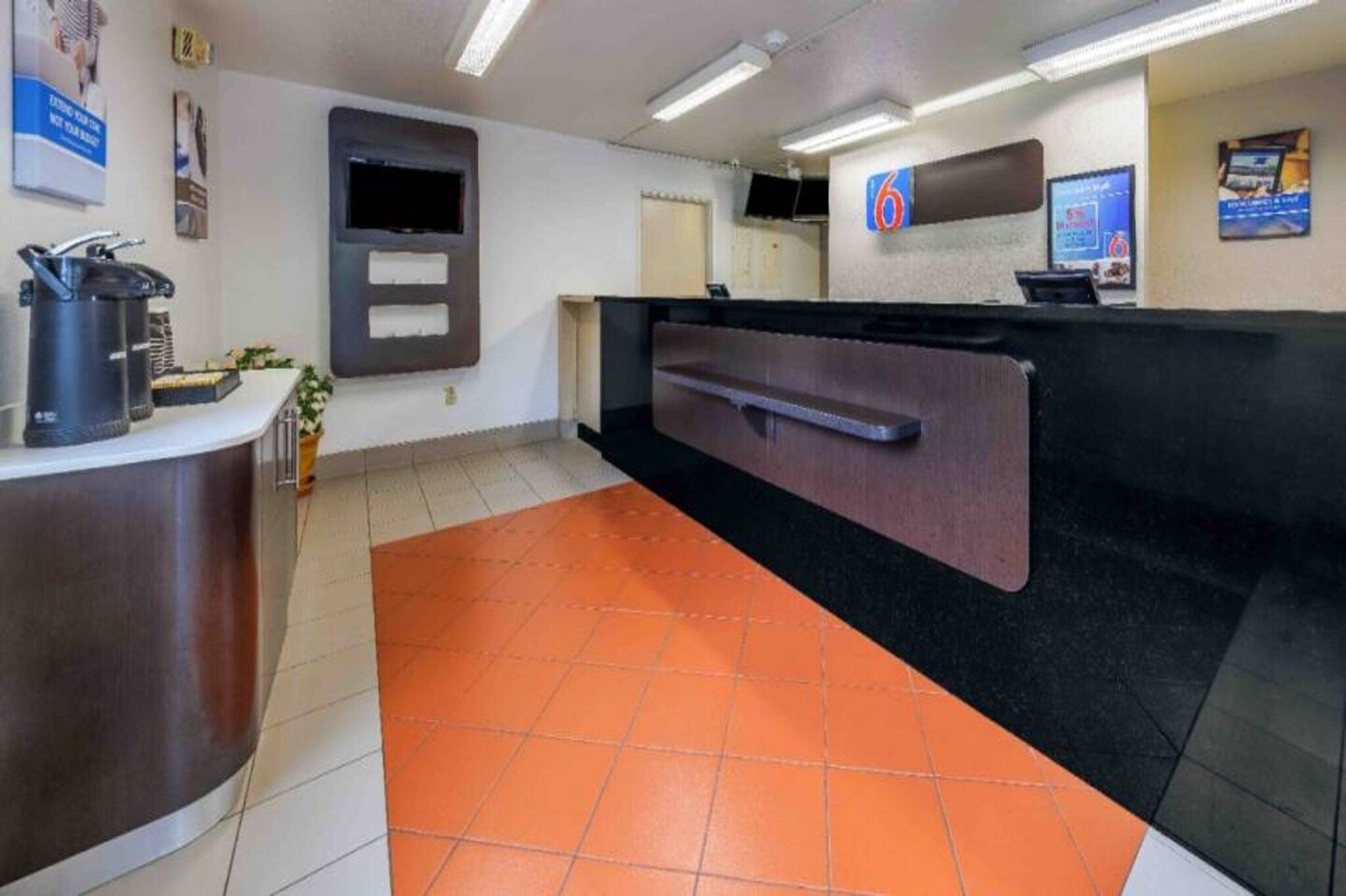 A reception area with a counter, a television, and a coffee machine.
