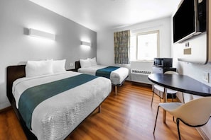 A hotel room with two beds, a desk, a chair, a TV, and a window with curtains. - 2 Full Beds | Non-Smoking (Seattle)