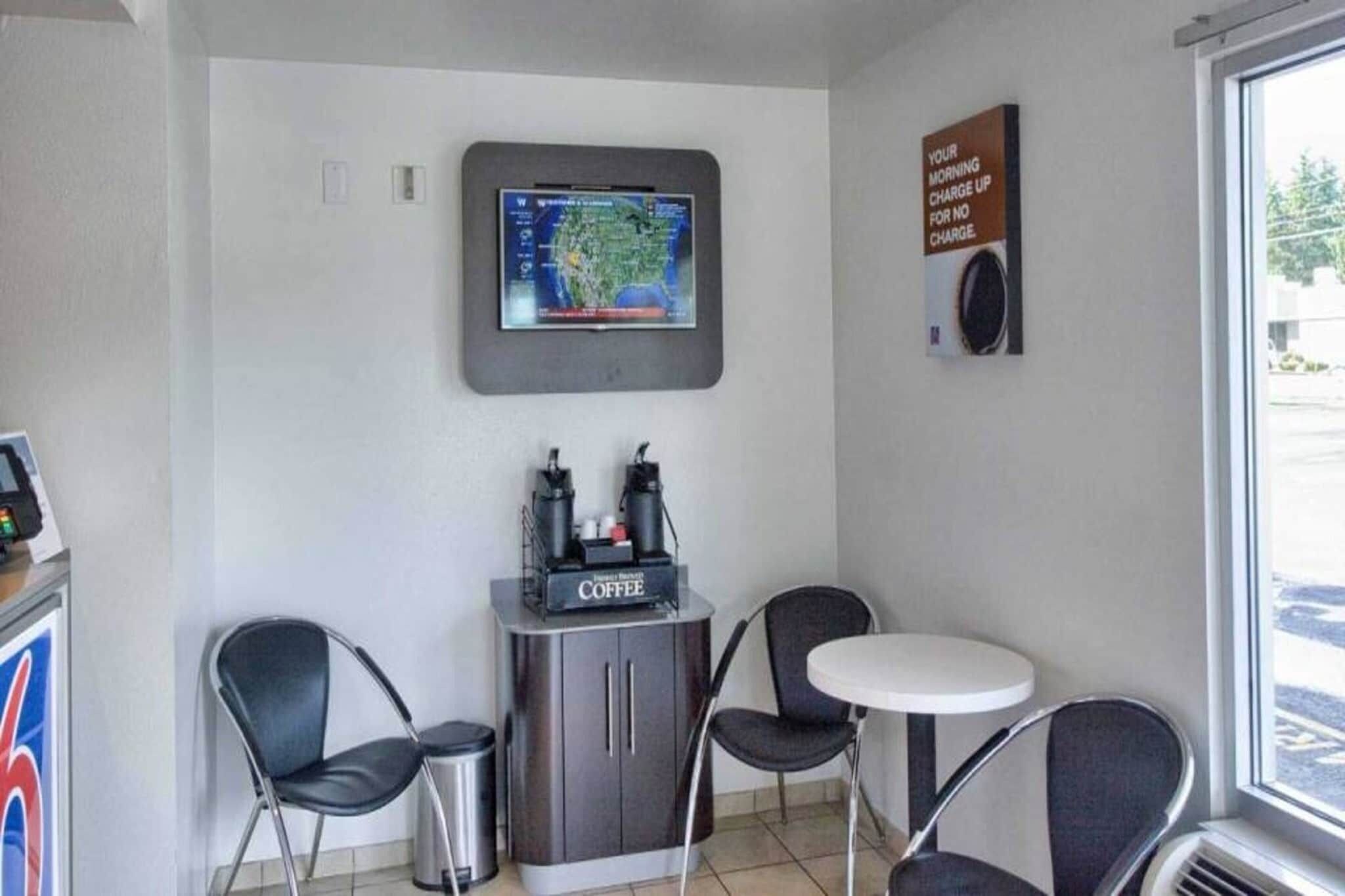 Een koffiehoekje met een koffieapparaat, twee stoelen en een tafel.