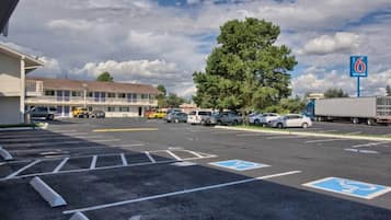 A parking lot with marked handicapped spaces, a motel building, and a truck.