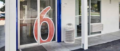 A building entrance with a 'welcome' sign and a large number '6' on the door.