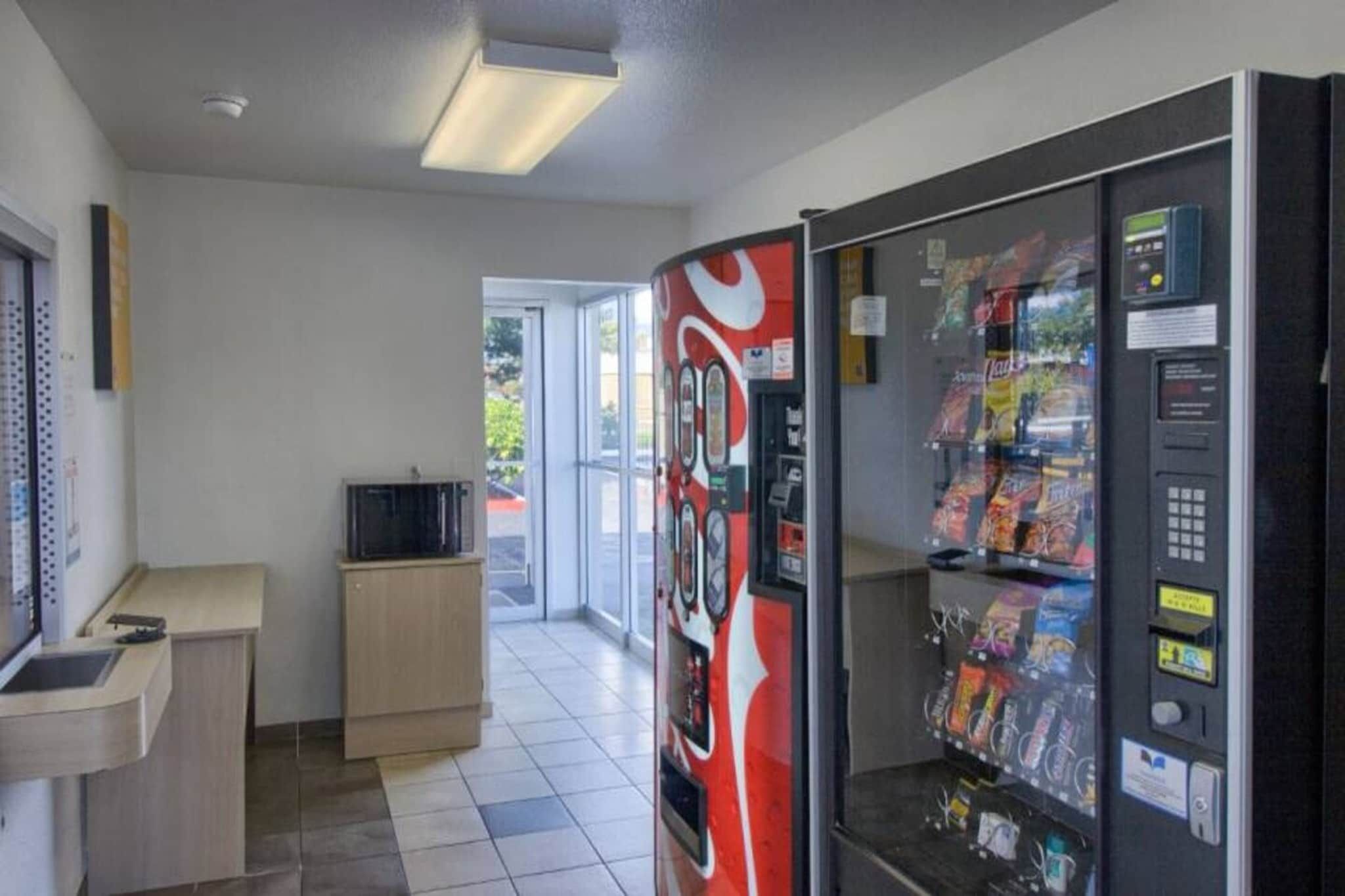 Et automatområde med en Coca-Cola automat, en mikrobølgeovn og en lille disk.