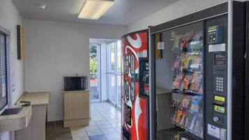 Et automatområde med en Coca-Cola automat, en mikrobølgeovn og en lille disk.