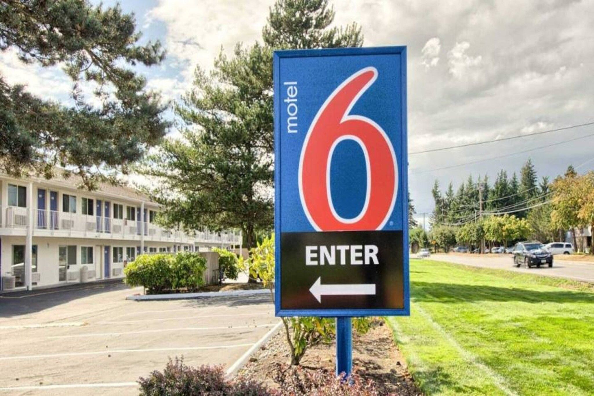 Une enseigne de motel avec le chiffre 6 et une flèche pointant vers la gauche, indiquant la direction de l’entrée.