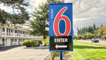 A motel sign with a number 6 and an arrow pointing left, indicating the entrance direction.