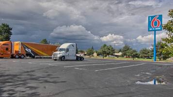 A parking lot with a large truck and a trailer, a clear sky, and a sign indicating WiFi availability.