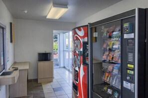 Een automatenruimte met snackautomaten en een televisie.