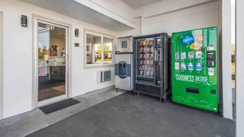 A building entrance with a water dispenser and a vending machine.