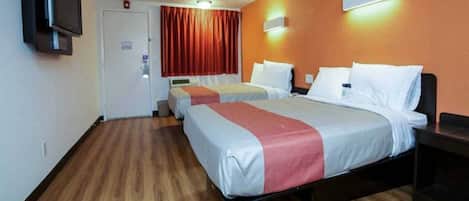 Quarto de hotel com duas camas, uma televisão fixada na parede e uma porta com interruptor de luz.