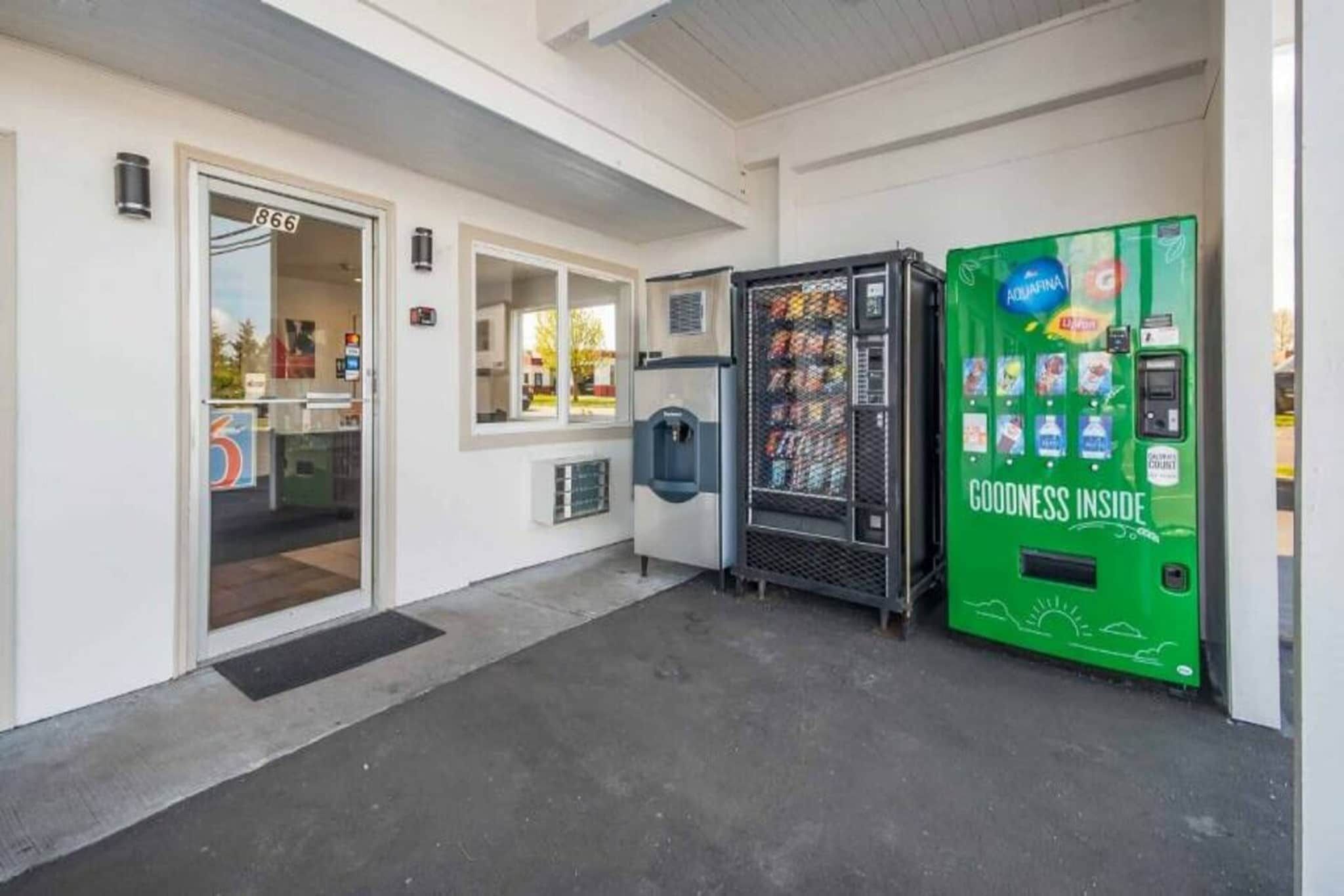 A building entrance with a water dispenser and a vending machine.