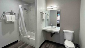 Um banheiro com chuveiro, pia e vaso sanitário.