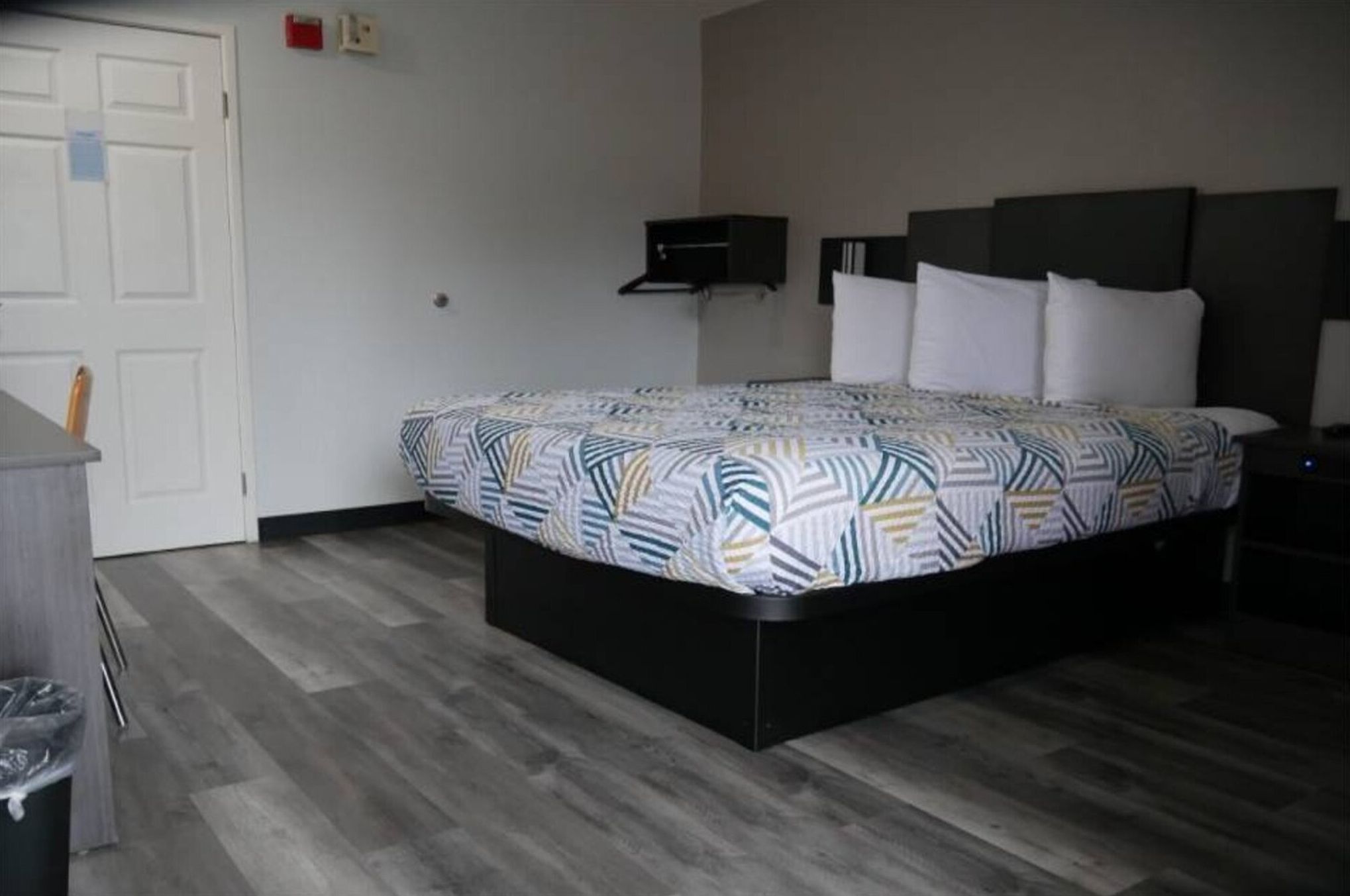 A hotel room with a bed, a desk, and a chair.